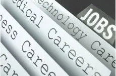 Job Search Assistance Close-up of categorized job listings, including technology, medical, and business careers, with the word "JOBS" visible.